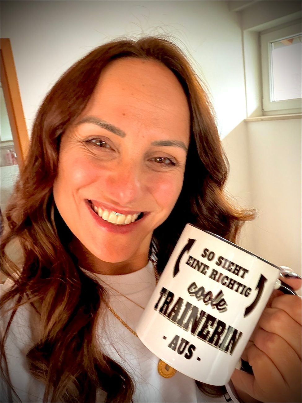 Tanja Dill lacht mit einer Tasse: So sieht eine richtig coole Trainerin aus